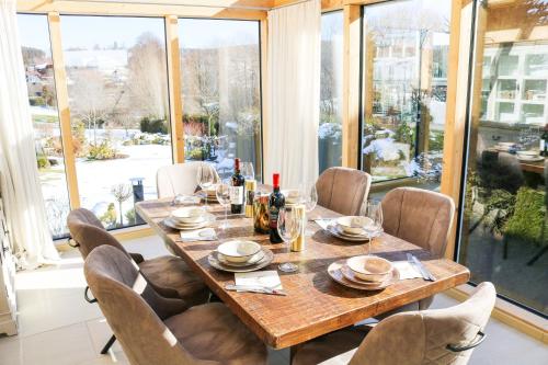 a dining room with a wooden table and chairs at Wolfsgrund Villa und/oder Apartment - Luxus in Seenähe mit tollem Garten in Schluchsee