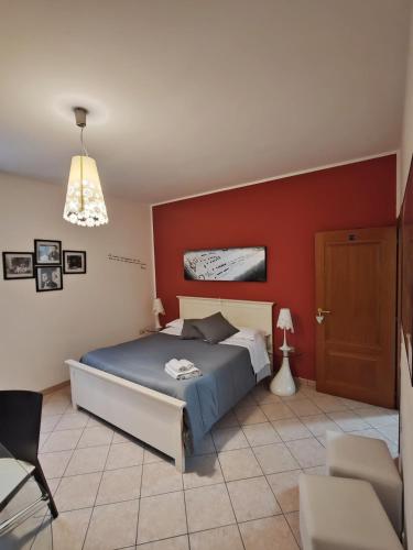 a bedroom with a bed and a red wall at B&B A Casa di Mael in San Costanzo