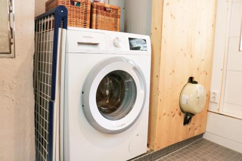 a washing machine in a laundry room with a wall at Wolfsgrund Villa und/oder Apartment - Luxus in Seenähe mit tollem Garten in Schluchsee