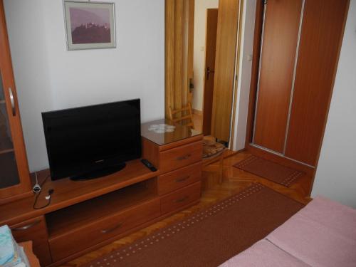a television on a wooden dresser in a bedroom at Nettes Appartement in Crikvenica mit Terrasse in Crikvenica