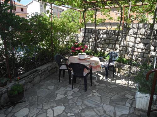 a patio with a table and chairs and a stone wall at Nettes Appartement in Crikvenica mit Terrasse in Crikvenica