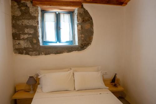 a bedroom with a bed and a window at Pappou's Traditional Cottage at Epano Elounda in Elounda