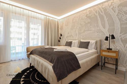 a bedroom with a bed and a wall with trees at Grand Suites Promenade in Budapest