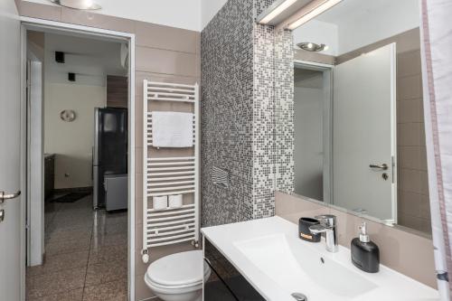 a bathroom with a toilet and a sink and a mirror at Cozy Apartment & Parking next to St Sophia Hospital in Sofia