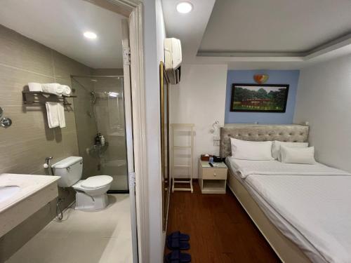 a bedroom with a bed and a shower and a toilet at A25 Hotel - 274 Đề Thám in Ho Chi Minh City