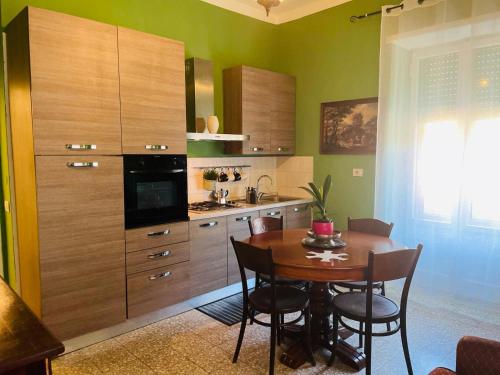 een keuken met een houten tafel en een keuken met groene muren bij Maremma Nel Tufo Centro in Pitigliano