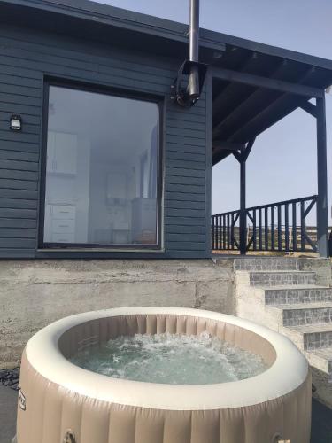 a hot tub in front of a house at Tiny House Maguri in Măguri