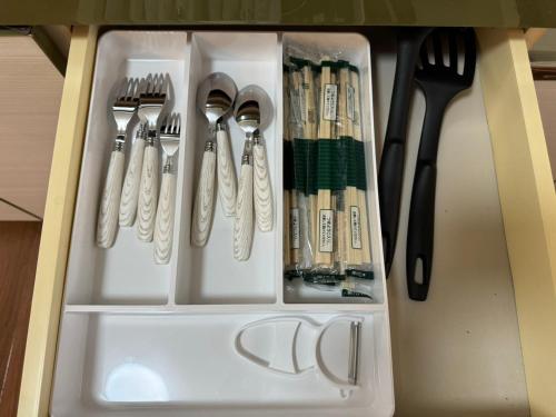 a drawer filled with utensils and forks and knives at OKAERI築地町 in Takamatsu