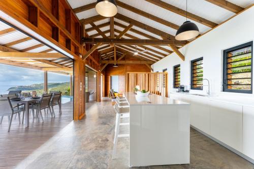 a kitchen with white countertops and wooden ceilings at Calypso Bay in Bouillante
