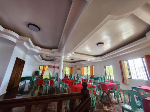 Hinunangan的住宿－Twin Island Beach House，一间用餐室,配有红色和绿色的桌椅