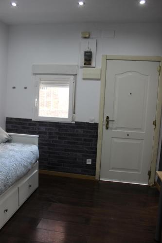 a bedroom with a white door and a window at Coqueta casita en Tetuán in Madrid