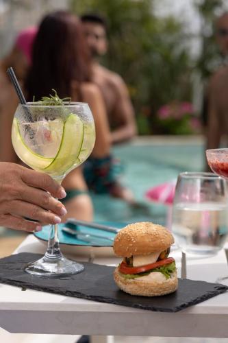 a sandwich and a drink on a table next to a pool at Bay Lodge Boutique Hotel in Jounieh