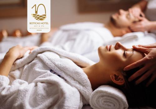 a woman laying on a bed under a towel at Boticas Hotel Art & SPA in Boticas