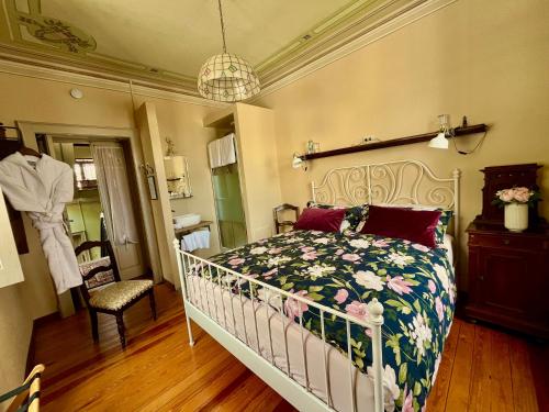 a bedroom with a bed with a floral bedspread at Villa il Maiale Bianco B&B in San Fedele Intelvi