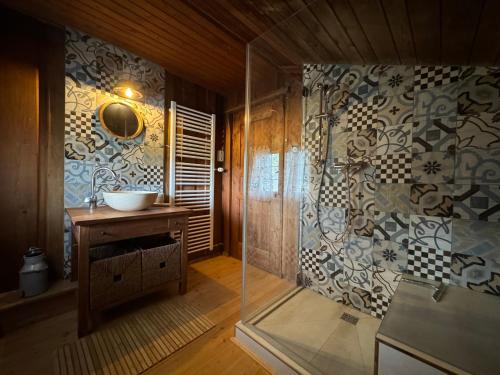 シュレヒングにあるHaus Bergsteigerglückの洗面台とガラスのシャワーを備えたバスルーム