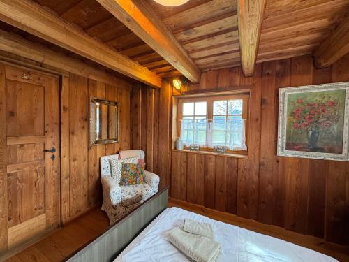 シュレヒングにあるHaus Bergsteigerglückのベッドと椅子と窓のある寝室