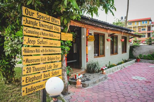 a sign with many signs in front of a building at Hotel Riverside with Swimming pool in Sauraha