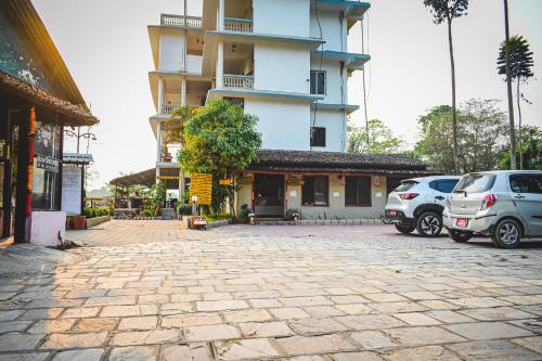 two cars parked in front of a building at Hotel Riverside with Swimming pool in Sauraha