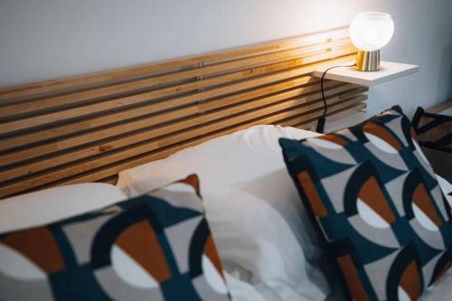 - une chambre avec un lit doté d'une tête de lit et d'une lampe dans l'établissement L'Atelier du Peintre • L'inattendu en centre-ville, à Châteauroux