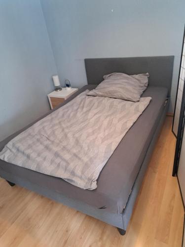a bed in a bedroom with a nightstand next to it at Zentrale Eigentumswohnung + kostenlosem Parkplatz in Sindelfingen