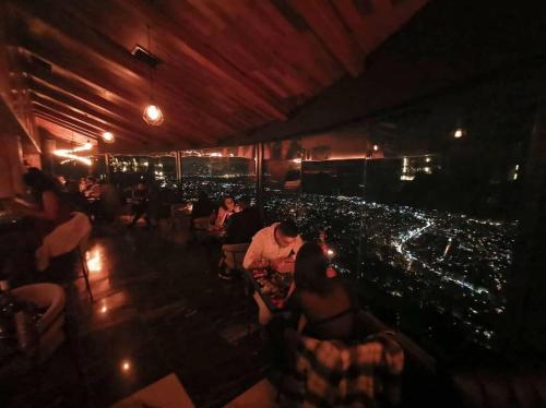 a group of people sitting in a restaurant at night at Bay Lodge Boutique Hotel in Jounieh