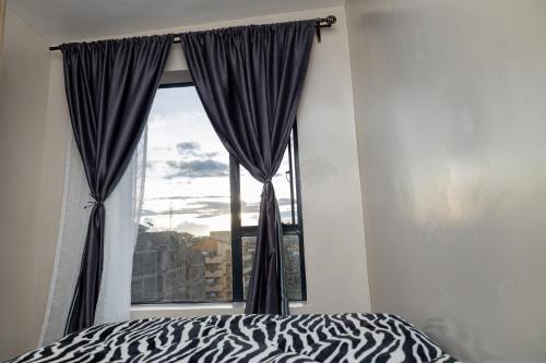 ein Schlafzimmer mit einem Fenster mit einem Zebra-Bett in der Unterkunft Cherry Home Stays KE in Nairobi
