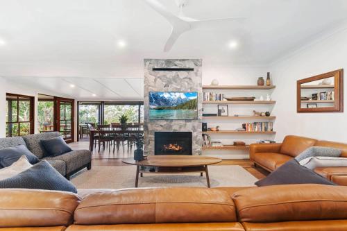 a living room with a couch and a fireplace at Executive Paradise High on Hill with Incredible Views, Firepit & Games Perfect for groups of Family and Friends in Balmoral Ridge