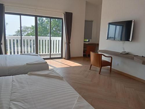 1 dormitorio con 1 cama, TV y silla en BOPHAMANSION en Phumĭ Ŏng Char