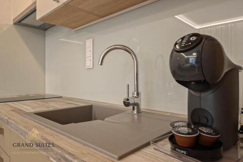 a kitchen counter with a sink next to a mixer at Grand Suites Promenade in Budapest