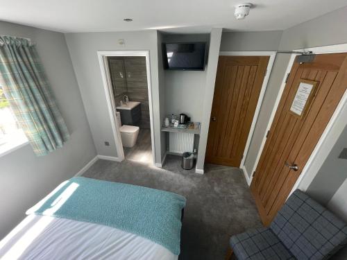 a small bedroom with a bed and a bathroom at Pen Mar Guest House B&B in Tenby