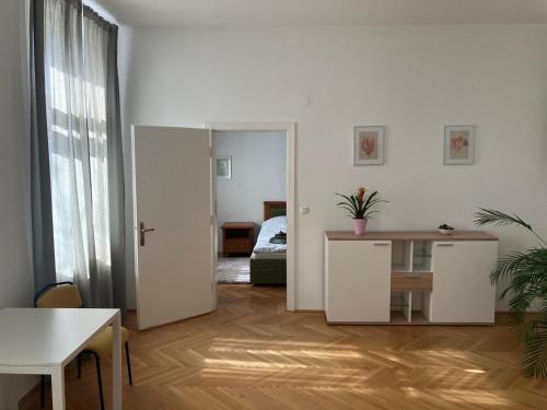 a living room with a table and a room with a bed at Ruhige Wohnung in Helenental in Baden