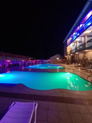 a swimming pool lit up at night with a building at Mountain Inn Hotel in Mbale