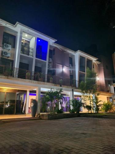 ein großes weißes Gebäude mit Balkon in der Nacht in der Unterkunft Mountain Inn Hotel in Mbale