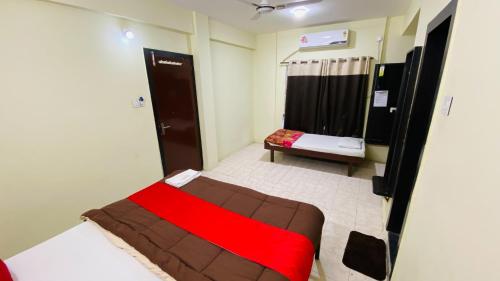 a bedroom with a bed with a red blanket at Hotel Uday Palace in Indore