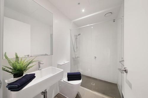 uma casa de banho com um lavatório, um WC e um chuveiro em A Stylish & Comfy 2BR Apt City Views in Southbank em Melbourne