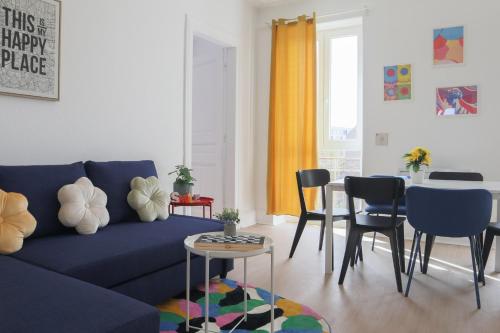 un salon avec un canapé bleu et des chaises dans l'établissement LE FUNNY, Mulhouse centre, à Mulhouse