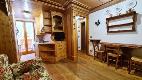 a kitchen with a table and a desk in a room at Appartamenti Home Service in Arabba