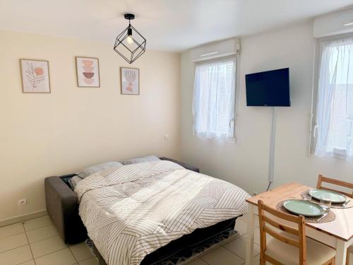 - une chambre avec un lit et une table dans l'établissement Charming & Cosy Apartment - 10mn from Disneyland, à Bussy-Saint-Georges