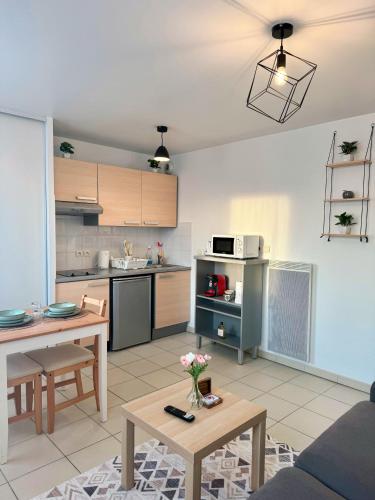 un salon avec une table et une cuisine dans l'établissement Charming & Cosy Apartment - 10mn from Disneyland, à Bussy-Saint-Georges