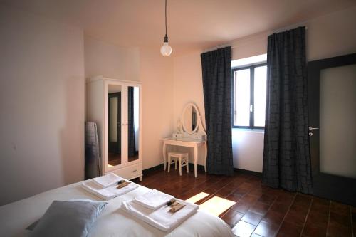 Un dormitorio con una cama, una mesa y un espejo. en Tre Finestre Sul Lago, en Perledo