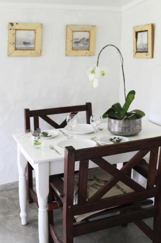 a white table with glasses and a plant on it at Arumvale Country Retreat in Swellendam