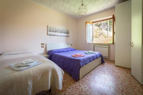 a bedroom with two beds and a window at La Casina del Teso in Maresca