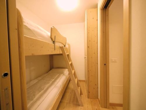 a bunk bed in a small room with a ladder at Appartamenti Home Service in Arabba