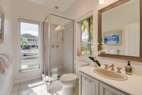 a bathroom with a toilet and a sink and a shower at Haven House by Brightwild - Luxury Waterfront in Key West