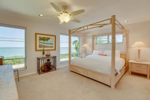 a bedroom with a canopy bed with a view of the ocean at Haven House by Brightwild - Luxury Waterfront in Key West