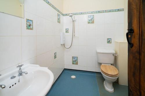 a bathroom with a sink and a toilet and a tub at Well Cottage - Compact & Cosy! in Buckinghamshire