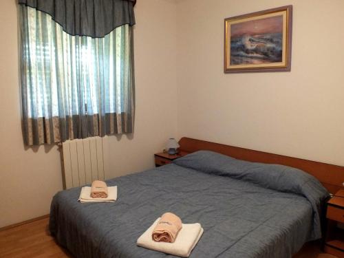 a bedroom with a bed with two hats on it at Villa Plavo more Fiorini in Umag