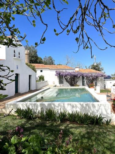 a swimming pool in the yard of a house at Casa De Santiago in Santiago do Cacém