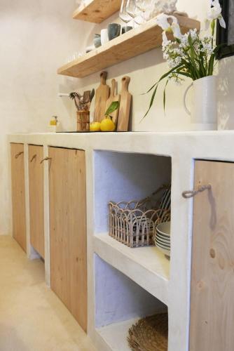 a kitchen with a white counter with wooden cabinets at Torre degli Svizzeri in Civezza