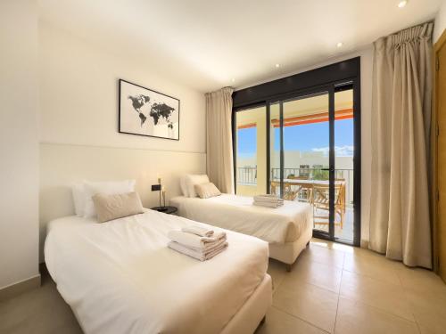 マルベーリャにあるSamara Resort Gym Spa Jacuzzi Pools Marbellaのバルコニー付きの客室内のベッド2台